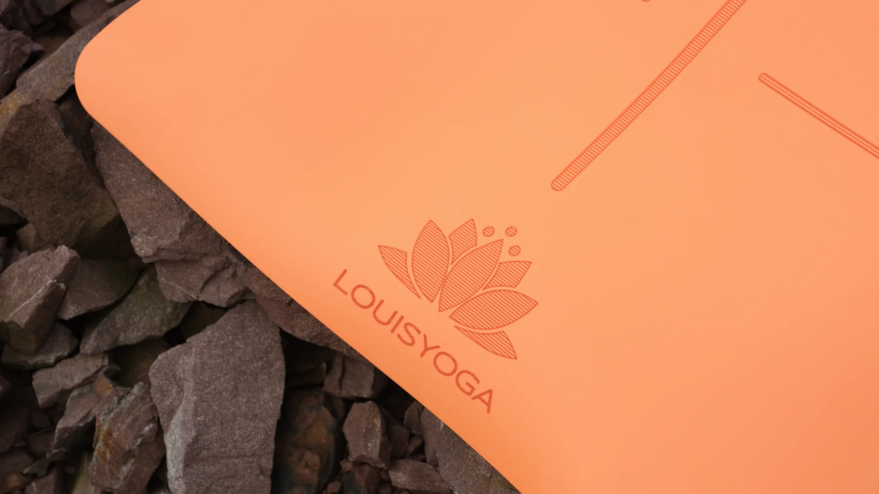 Cận cảnh bề mặt PU thảm yoga Louis Yoga màu cam, thấy rõ vạch laser định tuyến và logo hoa sen dập chìm