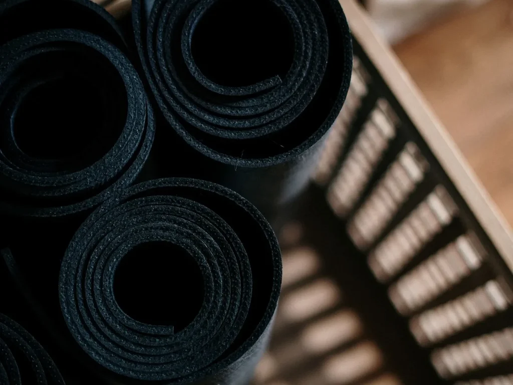 Những tấm thảm yoga cuộn tròn cất trong giỏ, nơi không có nắng trực tiếp