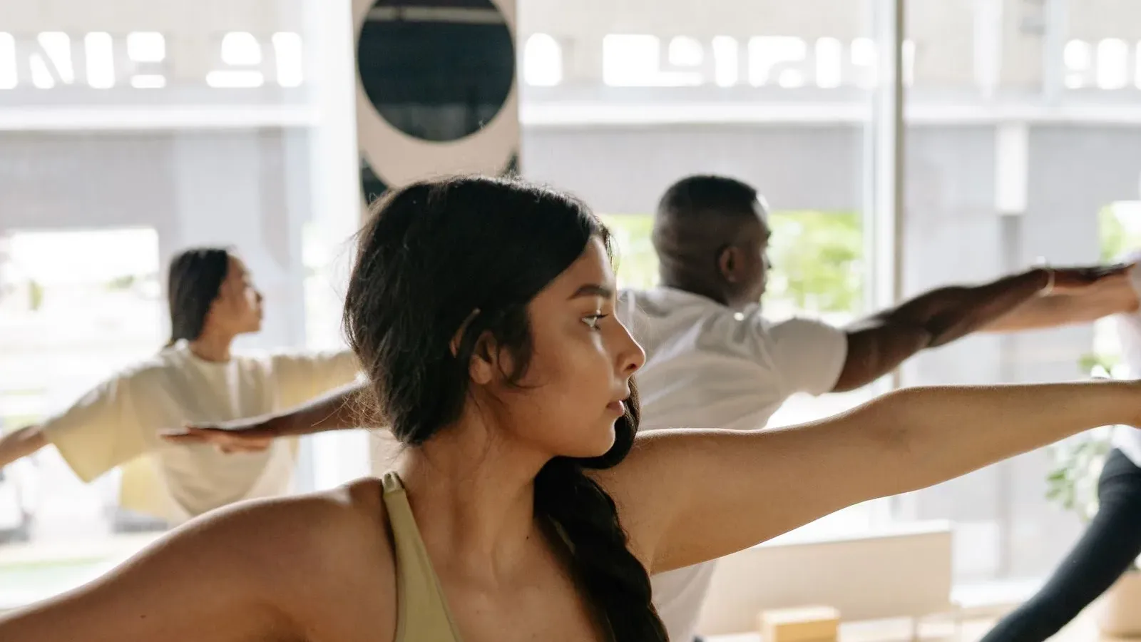 Người tập giữ tư thế chiến binh II trong lớp yoga, nhìn nghiêng